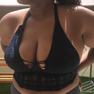K&ouml;nnte beinhalten: Ein dunkelblaues H&auml;kel-Halter-Top mit einem zarten Blumenmuster. Das Top ist aus einem weichen, leichten Material gefertigt und hat eine lockere Passform.