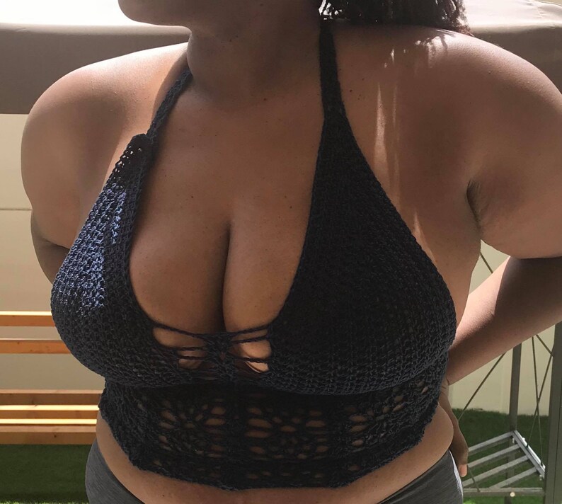 K&ouml;nnte beinhalten: Ein dunkelblaues H&auml;kel-Halter-Top mit einem zarten Blumenmuster. Das Top ist aus einem weichen, leichten Material gefertigt und hat eine lockere Passform.