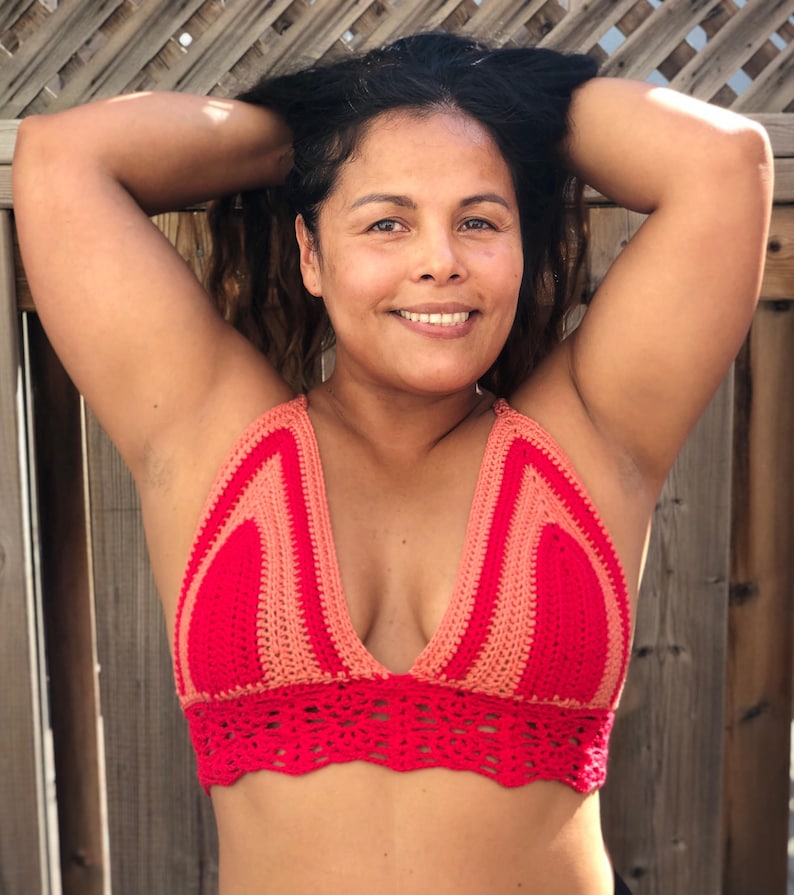 K&ouml;nnte beinhalten: Ein rotes und pfirsichfarbenes H&auml;kel-Halter-Top mit tiefem V-Ausschnitt und einem gewellten Saum.