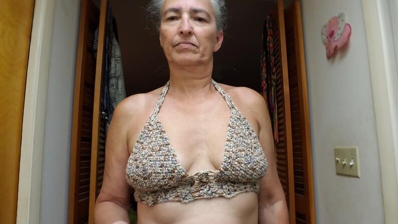 K&ouml;nnte beinhalten: Nahaufnahme einer Frau, die ein geh&auml;keltes Halstuch mit einem braunen, wei&szlig;en und blauen Farbmuster tr&auml;gt.