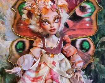 May include: A handmade doll with butterfly wings, a floral crown, and a pink and orange dress. The doll is holding a small glass bottle.