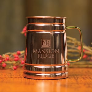 May include: A copper mug with a gold handle and the words "Mansion Ridge" and "MR" engraved on the front.