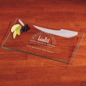 May include: A clear glass serving tray with an etched design that reads "Baton Rouge Growth Coalition Good Growth Award North Boulevard Town Square".