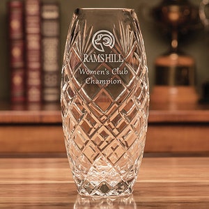 May include: A clear glass vase with a diamond pattern. The vase is engraved with the text "Ramshill Women's Club Champion" and a ram's head logo.