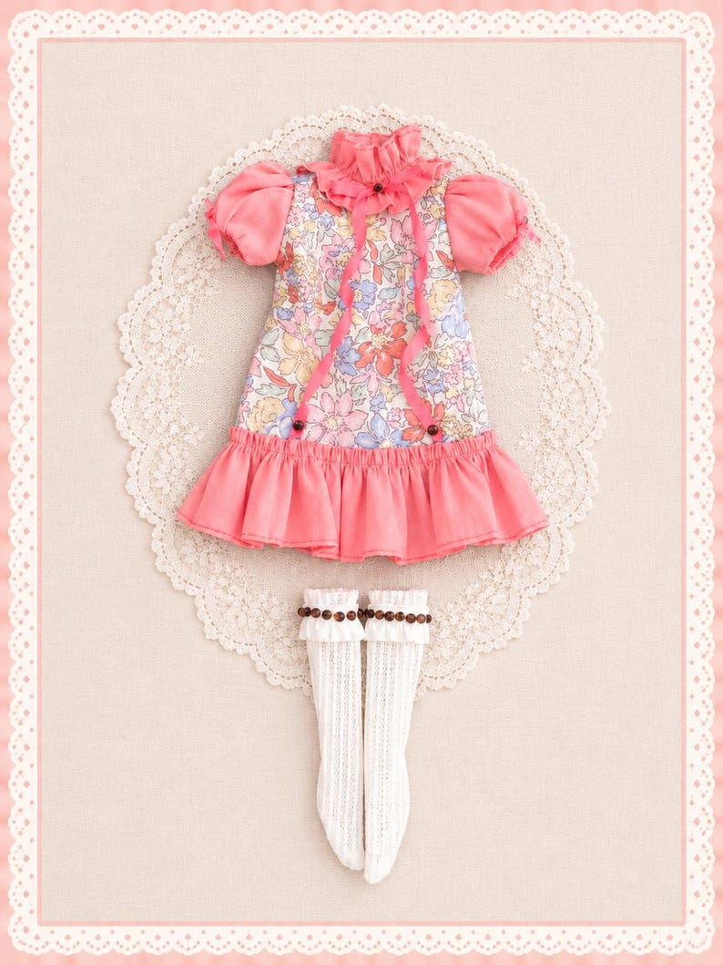 May include: A doll dress featuring a floral print bodice with pink puff sleeves, a ruffled collar with a thin pink ribbon, and a solid pink ruffled hem. The set includes a pair of white knee-high socks with a ribbed texture and brown bead trim.