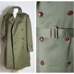 May include: A green double-breasted trench coat with a belt and brown buttons.