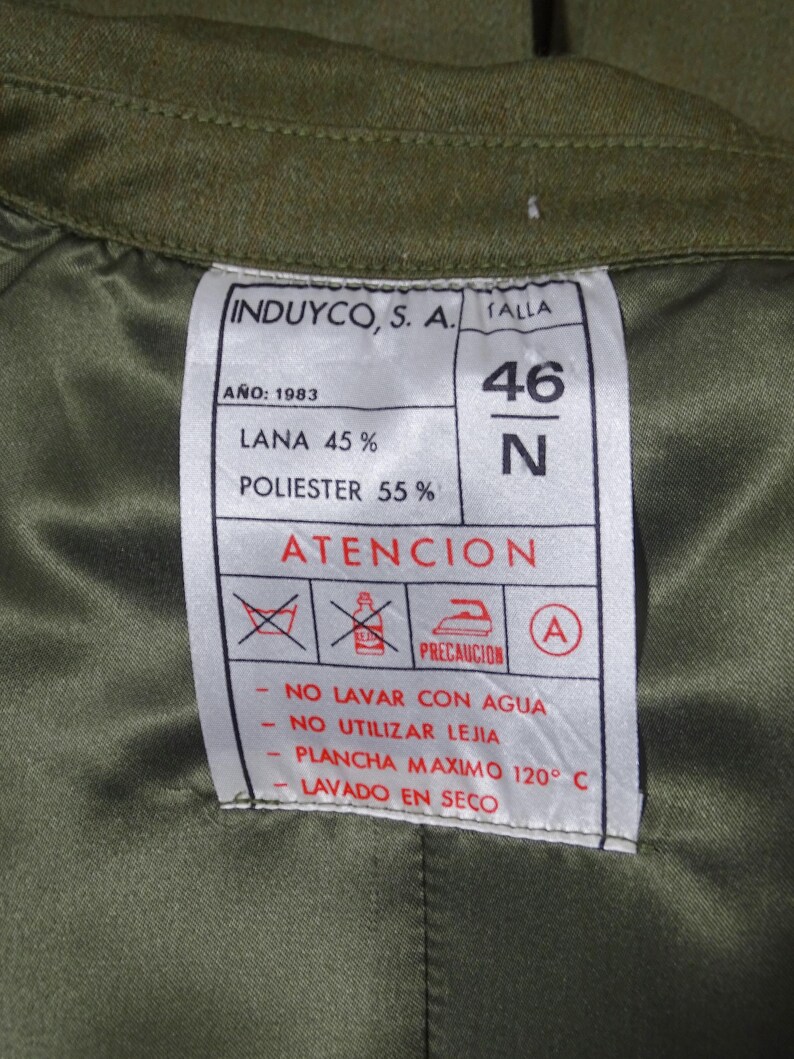 K&ouml;nnte beinhalten: Ein wei&szlig;es Etikett mit schwarzem Text, der "INDUYCO, S. A. FALLA ANO: 1983 LANA 45% POLIESTER 55% 46 N ATENCION PRECAUCION NO LAVAR CON AGUA NO UTILIZAR LEJIA PLANCHA MAXIMO 120&deg; C LAVADO EN SECO" lautet, mit einem roten Kreis mit einem Buchstaben A darin und einem roten Kreis mit einem durchgestrichenen Eimer und B&uuml;geleisen darin.
