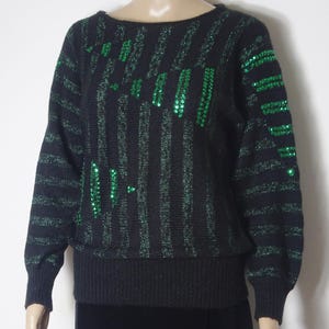 May include: Black and green striped sweater with green sequins in a geometric pattern.