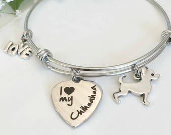 May include: Silver charm bracelet with a heart charm that says "I love my Chihuahua" and a small chihuahua charm. The bracelet also has a charm that says "love".