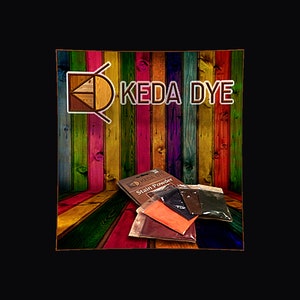 May include: A set of four wood stain powder packets in brown, black, red, and orange. The packets are labeled "Keda Dye Stain Powder". The packets are displayed on a background of colorful wooden planks.