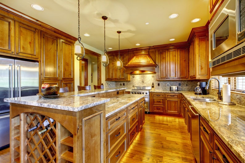 May include: A kitchen with wood cabinets, granite countertops, and stainless steel appliances. The kitchen features a large island with a wine rack and a breakfast bar.