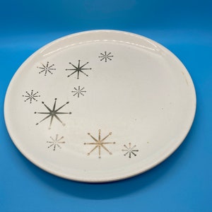 May include: White ceramic dinner plate with a silver starburst pattern.