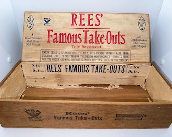 May include: A vintage wooden box with a faded label that reads "Rees' Famous Take-Outs" and "2 for 5cts." The box is open and empty. The label also includes the text "Every cigar a splendid quality, mild, free-burning smoke - made from tobacco especially selected for its ripeness and fragrance - tobacco from all the choice growing sections, blended to please 100% of the smokers."
