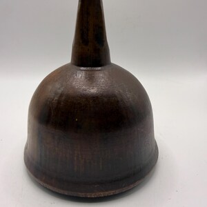 May include: A dark brown, bell-shaped funnel with a smooth, rounded body and a tapered, cylindrical spout at the top. The object features a deep, uniform wood-toned finish with subtle variations in color and a wide, circular base opening.