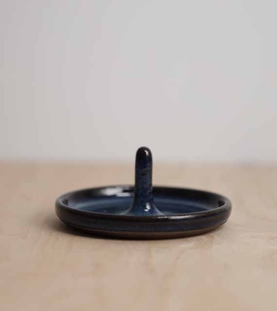 Blue Storm ring holder. Piece is 4 inches wide, circular, and has a 2 inch stem that sticks up from the middle.