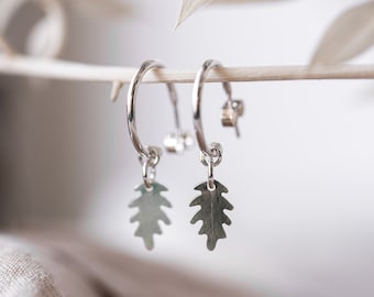 Silver Open Hoop Earrings With A Dangling Oak Leaf Charm. Polished Silver Hoops With Hand Cut Oak Leaves That Move To Catch The Light.