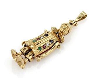 May include: A gold-toned pendant charm in the shape of a jester with colorful gemstones. The jester is wearing a hat and has a playful expression.