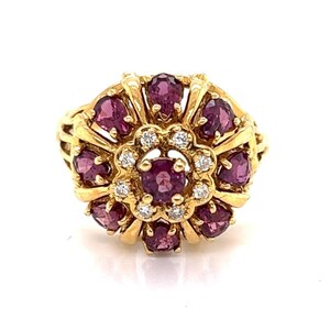 May include: A gold ring with a cluster of pink gemstones and diamonds. The ring has a floral design.