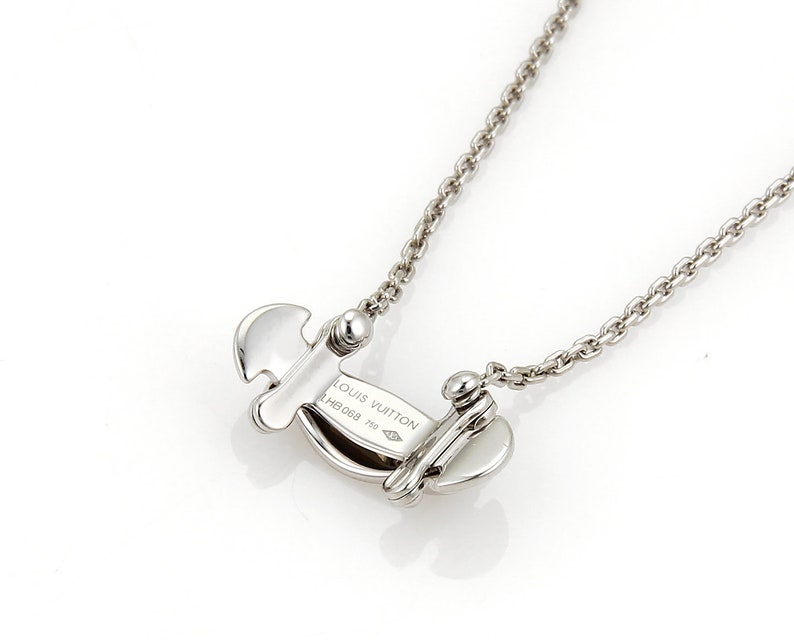 Puede incluir: Un collar de plata con un colgante de plata que dice "LOUIS VUITTON" y "M6098 750".