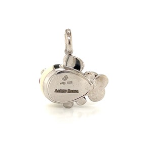 May include: White gold charm pendant featuring a stylized fish with black and red enamel accents. The back of the charm is engraved with "Aaron Basha".