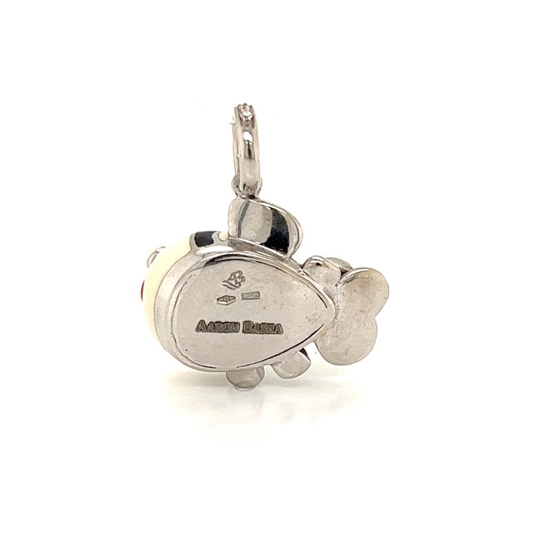 May include: White gold charm pendant featuring a stylized fish with black and red enamel accents. The back of the charm is engraved with "Aaron Basha".