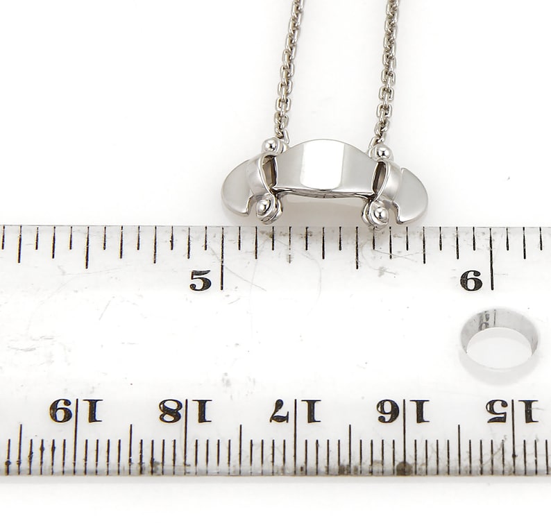 Puede incluir: Un collar de plata con un peque&ntilde;o colgante rectangular. El colgante mide aproximadamente 2,5 cm de largo y tiene una superficie lisa y pulida. El collar mide aproximadamente 45 cm de largo y tiene una cadena delicada.