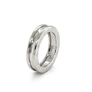 May include: A silver ring with a rotating band featuring engraved numbers around the circumference.