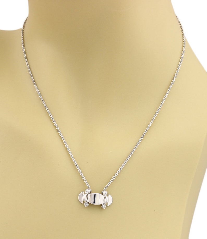 Puede incluir: Un collar de cadena de plata con un peque&ntilde;o colgante de monopat&iacute;n de plata.