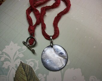 Necklace, ribbon with silver pendant.