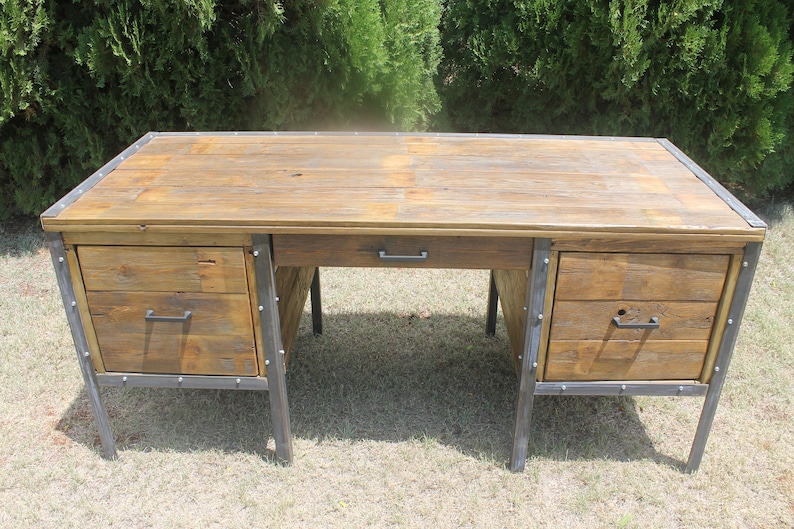 May include: A rustic wooden desk with metal accents and drawers. The desk has a natural wood finish and features metal legs and drawer pulls.