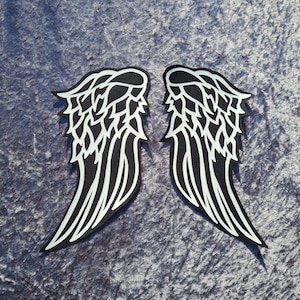 Ailes d'ange noires et blanches faites à la main. Larges empiècements dans le dos de la veste.