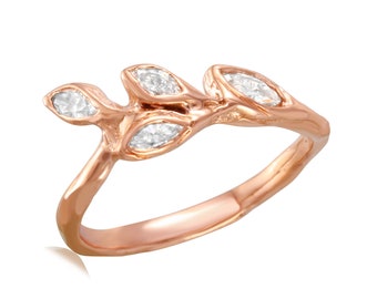 May include: A rose gold ring with a delicate branch design featuring three small, clear diamonds.