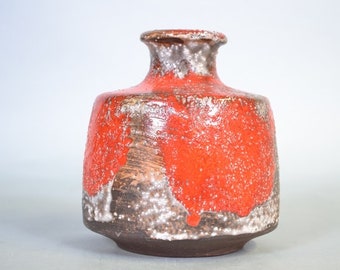 Może przedstawiać: Mały, pomarańczowo-brązowy wazon ceramiczny z fakturowaną powierzchnią. Wazon ma szeroką podstawę i wąską szyjkę.