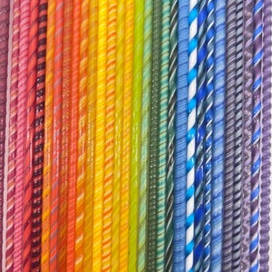 May include: A vibrant array of colorful, twisted glass rods. The rods display a spectrum of colors, including red, orange, yellow, green, blue, and purple. Each rod has a unique pattern of stripes and swirls, creating a visually appealing display.