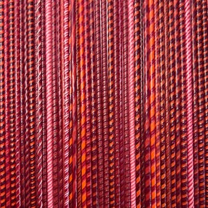 Puede incluir: Primer plano de una colección de coloridos bastones de caramelo retorcidos. Los palos son principalmente rojos, rosas y naranjas, algunos con un patrón de rayas. La disposición crea un fondo texturizado visualmente atractivo, que sugiere un dulce.