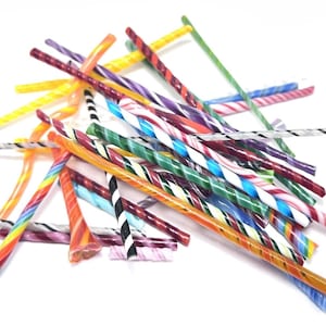 May include: A pile of colorful, swirled glass candy sticks. The sticks are in various colors, including red, blue, green, yellow, and orange, with some having striped patterns. The candy sticks are a fun and festive treat.