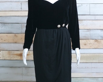 Könnte beinhalten: Ein schwarzes Samt- und Rockkleid mit einem herzförmigen Ausschnitt und zwei Perlenknöpfen an der Taille.