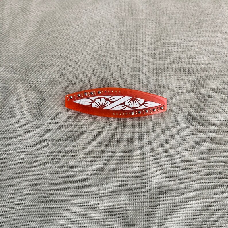 1930 brooch in orange acetate.
