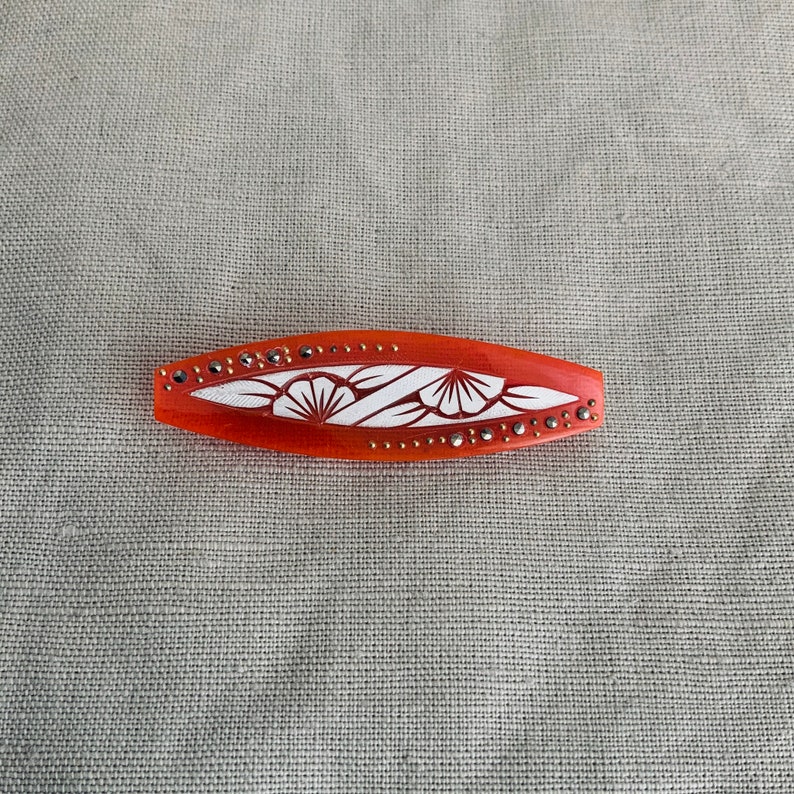 1930 brooch in orange acetate.