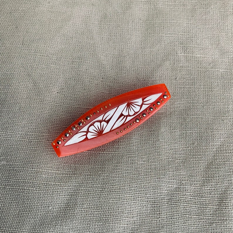 1930 brooch in orange acetate.