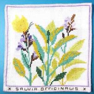 Puede incluir: Bordado a punto de cruz de salvia, con flores y hojas amarillas, verdes y moradas sobre un fondo blanco. El dise&ntilde;o incluye el texto "SALVIA OFFICINALIS" en la parte inferior, enmarcado por un borde lavanda.