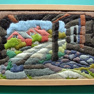 Vintage 1970s multicolor hecho a mano hilo de lana por todo el frente longstitch flatseam tapiz colgante de pared con motivo de casas de pueblo antiguas, marco de madera