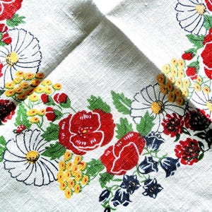 Könnte beinhalten: Weißes Leinentuch mit einem Blumenmuster aus roten Rosen, weißen Gänseblümchen, gelben Büscheln und blauen Akzenten. Das Wort "Sandra" ist auf dem Tuch aufgedruckt.