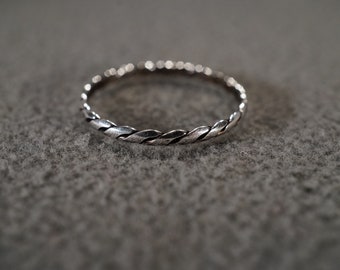May include: A silver ring with a braided design.