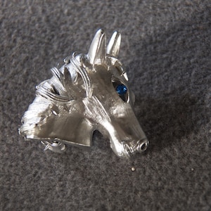 vintage silver tone pin brooch in the form of a horse head in profile with blue rhinestone eye      M