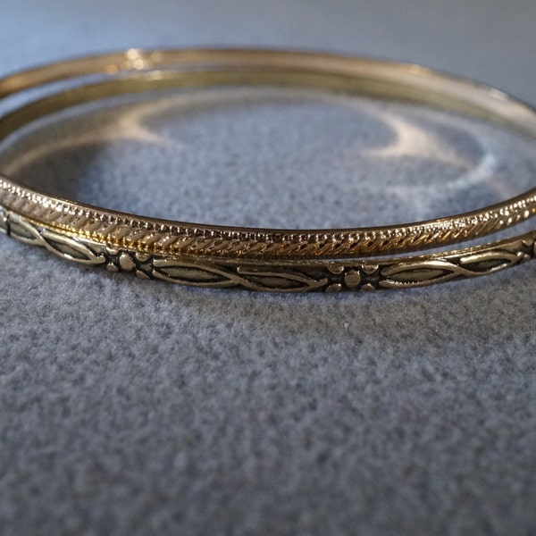 set of 2 vintage gold tone bangle bracelets etched in different designs      M