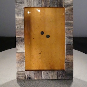 May include: A rectangular picture frame made of light brown wood with a dark brown border. The frame has a light brown mat and a clear glass front. The frame is empty.