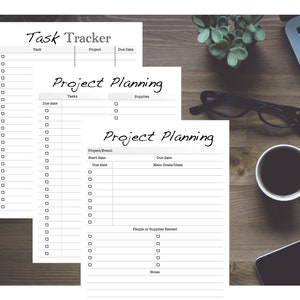 May include: A set of printable task tracker and project planning sheets. The sheets are white with black text and lines. The sheets are on a wooden surface with a laptop, a cup of coffee, and a pair of glasses.