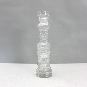 Puede incluir: Un candelabro de vidrio transparente con una superficie texturizada y burbujeante que presenta una serie de segmentos redondeados apilados. El diseño incluye una base circular ancha, una columna central cónica con crestas horizontales y una abertura superior ensanchada.