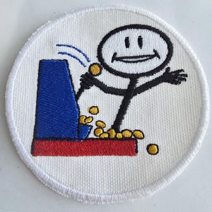 May include: A white, circular patch with a cartoon illustration of a stick figure playing an arcade game. The arcade machine is blue and red, with gold coins spilling out. The stick figure is black and smiling.